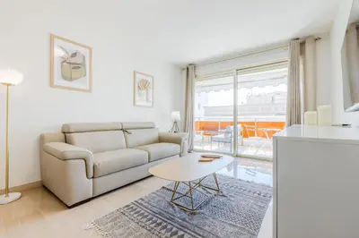 a living room with a couch and a table at Stylish 1-Bedroom Apartment Close to Beaches in Cannes