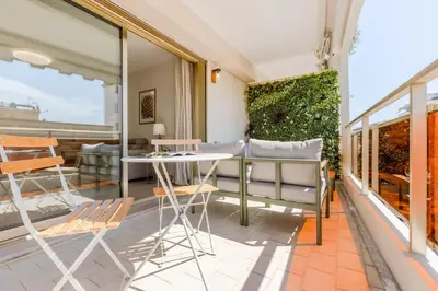 a patio with a table and chairs on a balcony at Stylish 1-Bedroom Apartment Close to Beaches in Cannes