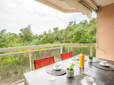 a table with chairs and a balcony with a view at Apartment La Croix des Gardes by Interhome in Cannes