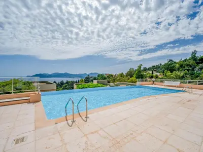 a swimming pool in a villa with a view of the water at Apartment La Croix des Gardes by Interhome in Cannes
