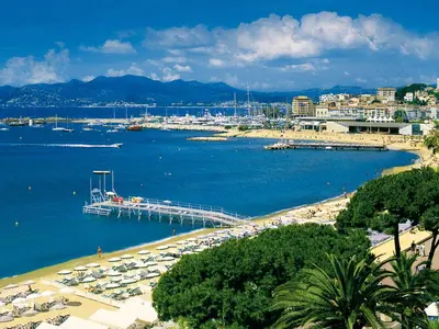 a beach with a pier and boats in the water at Apartment La Croix des Gardes by Interhome in Cannes