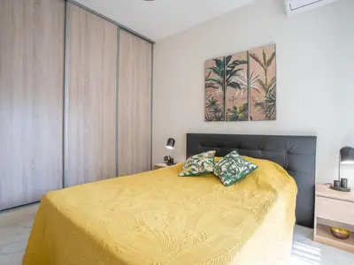a bedroom with a bed with a yellow bedspread at Apartment Le Puget by Interhome in Cannes