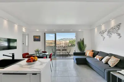 a living room with a blue couch and a table at CROISETTE BEACH - Modern 2 Bdrs Best Location! in Cannes