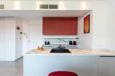 a kitchen with red cabinets and a sink at CROISETTE BEACH - Modern 2 Bdrs Best Location! in Cannes