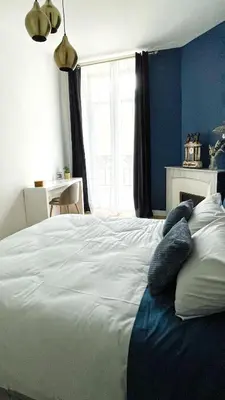 a living room with a blue wall and a fireplace at Le Cannois by Coeur de Loup in Cannes