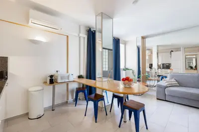 a kitchen and living room with a table and a couch at 45 Croisette Apartment - Prime Location - Beach & Palais by Foot - AC in Cannes