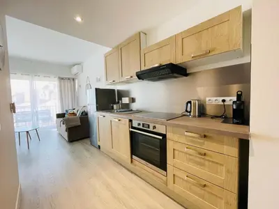 a kitchen with wooden cabinets and a stove top oven at La Suquetane in Cannes