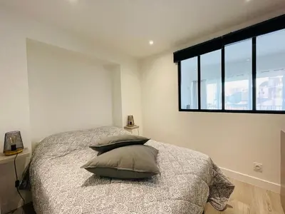 a bedroom with a bed with two pillows and a window at La Suquetane in Cannes