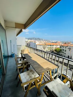 a balcony with a wooden table and chairs at La Suquetane in Cannes