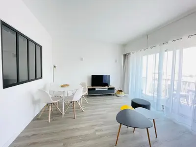 a white living room with a table and chairs at La Suquetane in Cannes