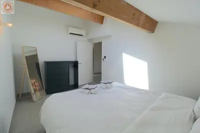 a white bedroom with two cats sitting on a bed at ALC - MONT8 - 8 min Palais and Beaches in Cannes
