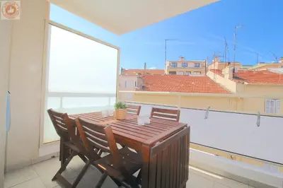 a wooden table and chairs on a balcony with a view at ALC - MONT8 - 8 min Palais and Beaches in Cannes