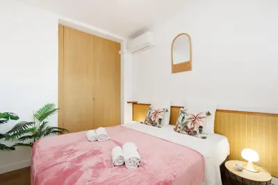 a bedroom with a pink bed with slippers on it at Palais des Iles YourHostHelper in Cannes