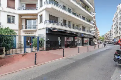a building on a city street with a fence at Palais des Iles YourHostHelper in Cannes
