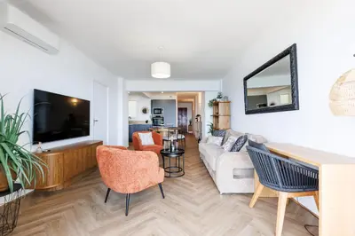 a living room with a couch and a tv at Palais des Iles YourHostHelper in Cannes