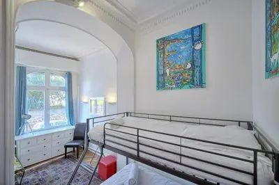 a bedroom with a bed and a painting on the wall at IMMOGROOM -Terrace with garden - Quiet - Air-conditioner in Cannes