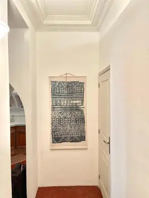 a white hallway with a painting on the wall at Great studio in the heart of Cannes Meynadier old city neighbourhood ! in Cannes