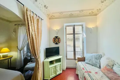 a bedroom with a bed and a tv and a window at Great studio in the heart of Cannes Meynadier old city neighbourhood ! in Cannes