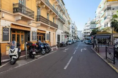 a street with motorcycles parked on the side of the road at Cosy apartment 39M2, two steps from rue d'Antibes and Croisette in Cannes
