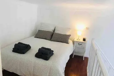 a bedroom with a white bed with two black pillows at MIPIM Rue Montaigne, 200m Palais des festivals in Cannes