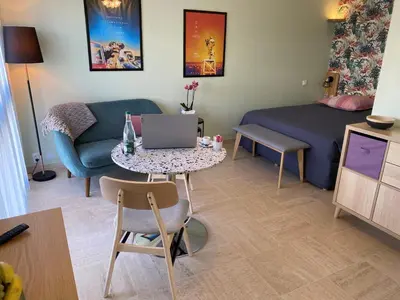 a living room with a couch and a table with a laptop at Studio Mimosa Croisette in Cannes
