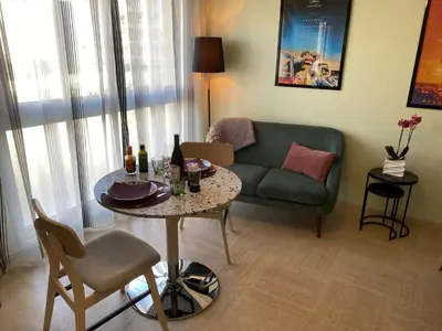 a living room with a table and a couch at Studio Mimosa Croisette in Cannes