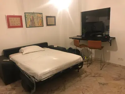 a bedroom with a bed and a desk and a television at La Rotonde in Cannes