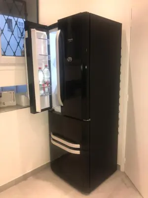 a black refrigerator with its door open in a kitchen at La Rotonde in Cannes