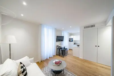 a living room with a white couch and a table at Luxury Apartment 100 m to Palais des Festivals in Cannes