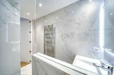 a white bathroom with a sink and a mirror at Luxury Apartment 100 m to Palais des Festivals in Cannes