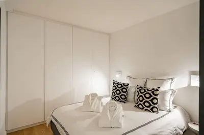 a white bedroom with a bed with two towels on it at Luxury Apartment 100 m to Palais des Festivals in Cannes