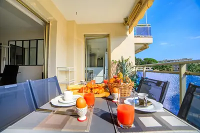 a table with a bowl of fruit on a balcony at Le Prado Parc in Cannes