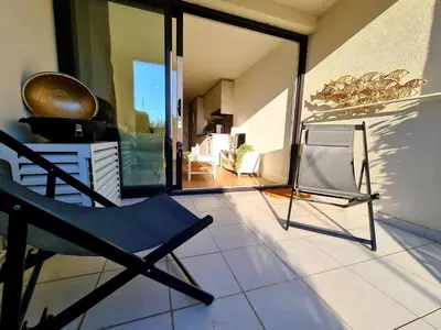 a chair sitting on a tile floor in a room at Appartement 0321, piscine - parking - proche plages - Palmazur Vacances in Cannes