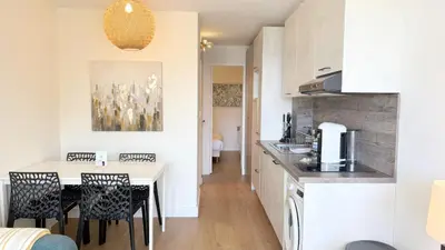 a kitchen and dining room with a table and chairs at Appartement 0321, piscine - parking - proche plages - Palmazur Vacances in Cannes