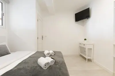 a white bedroom with towels on a bed at Great Sea View YourHostHelper in Cannes