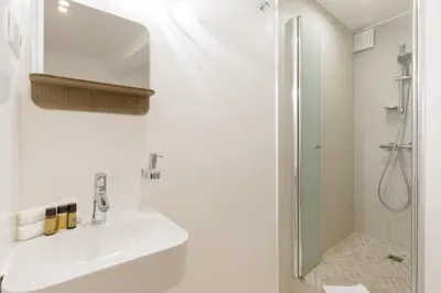 a white bathroom with a sink and a shower at Great Sea View YourHostHelper in Cannes