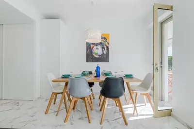 a dining room with a wooden table and chairs at 90m on the Croisette with Terrace & Sea View in Cannes