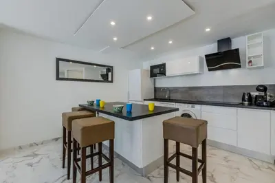 a kitchen with a counter and stools in it at 90m on the Croisette with Terrace & Sea View in Cannes