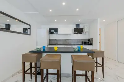 a kitchen with a counter and stools in a room at 90m on the Croisette with Terrace & Sea View in Cannes