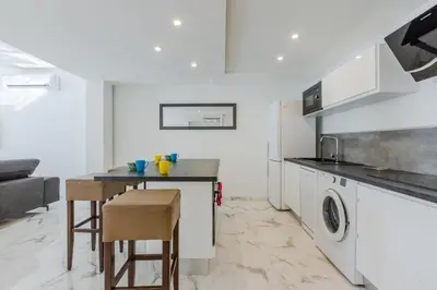 a kitchen with a table and a washer and dryer at 90m on the Croisette with Terrace & Sea View in Cannes