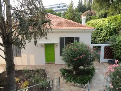a small white house with a green door at SUPERBE MAISON DE VILLE in Cannes