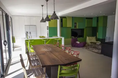 a kitchen with a wooden table and green walls at SUPERBE MAISON DE VILLE in Cannes