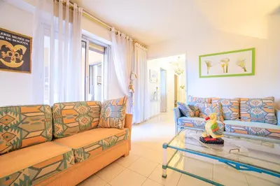a living room with a couch and a glass table at Appartement Les Allées in Cannes