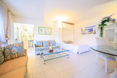 a living room with a couch and a bed at Appartement Les Allées in Cannes