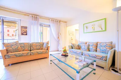 a living room with two couches and a glass table at Appartement Les Allées in Cannes