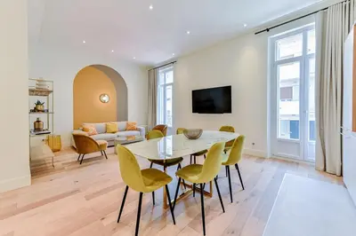 a living room with a table and chairs and a couch at Luxury Apartment - Heart of Cannes - Rue d'Antibes in Cannes