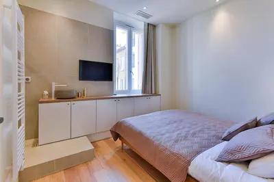 a bedroom with a bed and a flat screen tv at Luxury Apartment - Heart of Cannes - Rue d'Antibes in Cannes