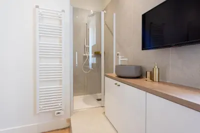 a bathroom with a sink and a television on a counter at Luxury Apartment - Heart of Cannes - Rue d'Antibes in Cannes