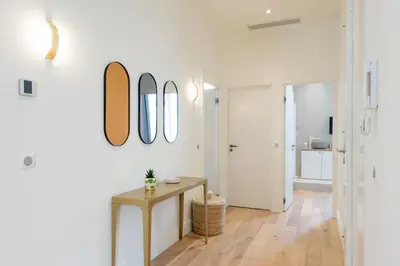 a white room with a table and mirrors on the wall at Luxury Apartment - Heart of Cannes - Rue d'Antibes in Cannes