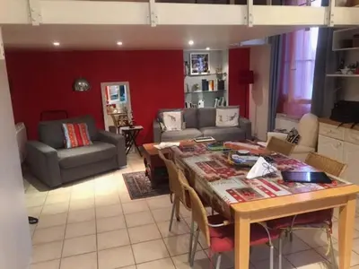 a living room with a table and a couch at Charmant appartement dans villa avec parc in Cannes